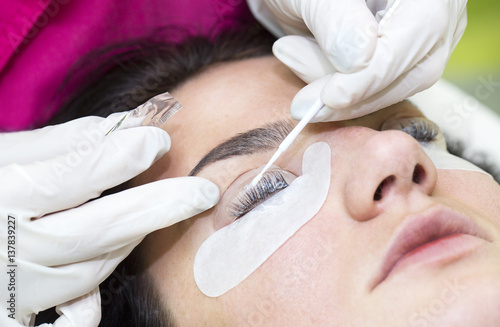 Woman on the procedure for eyelash extensions, eyelashes lamination  photo