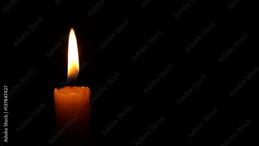 Closeup of one candle burning at night on black background. Closeup of one candle burning at night on black background.