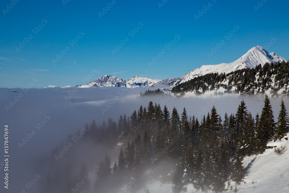 Mountains covered with snow and surrounded by clouds