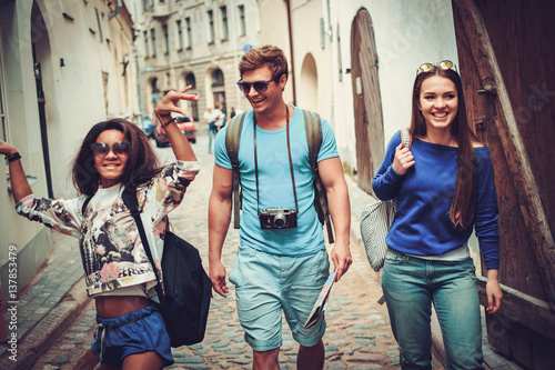 Multi ethnic friends tourists with map in old city