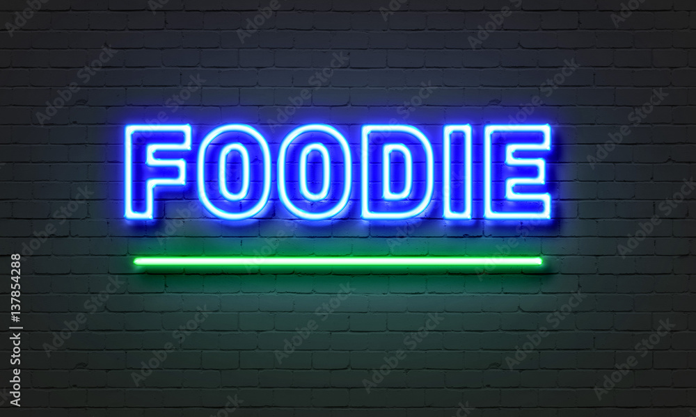 Foodie neon sign on brick wall background. Foodie neon sign on brick wall background.