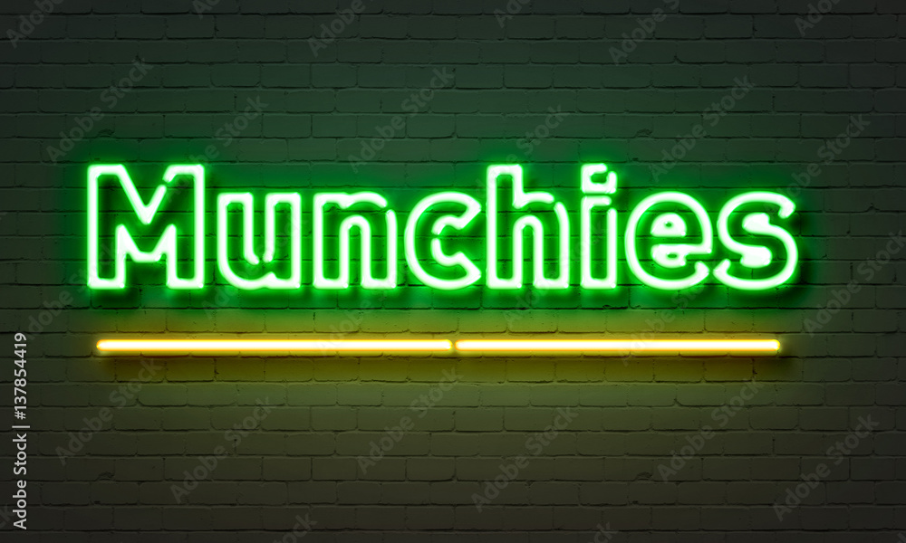Munchies neon sign on brick wall background.