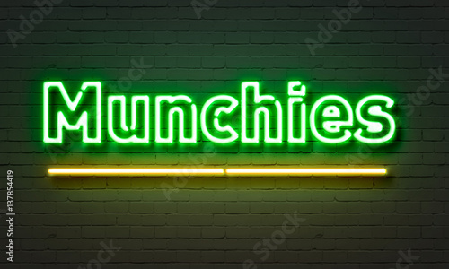 Munchies neon sign on brick wall background. photo