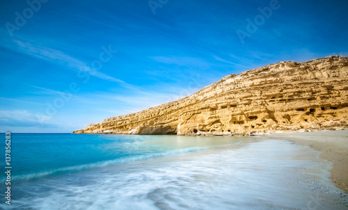 Panorama of Matala beach with the caves on the rocks that were used as a roman cemetery and at the decade of 70's were living hippies from all over the world, Crete, Greece