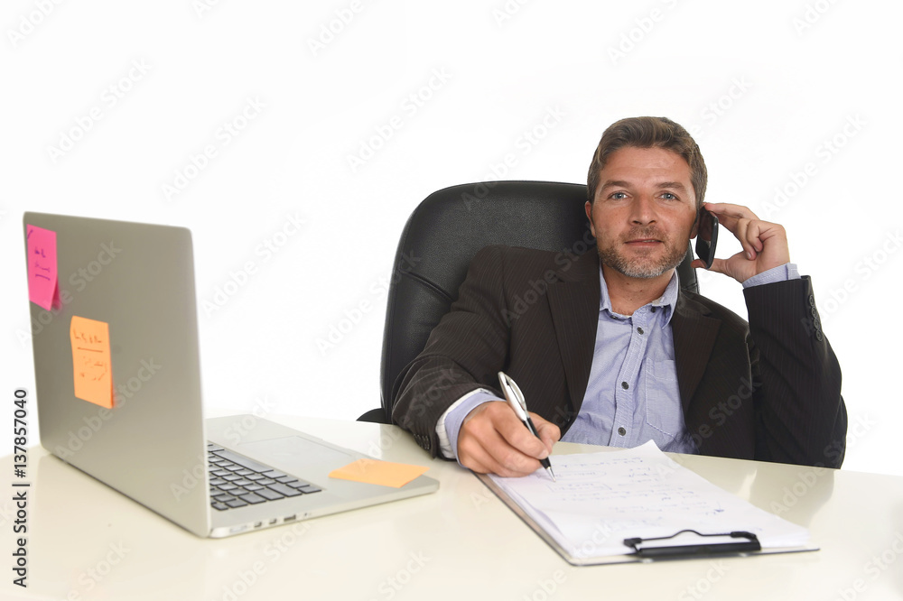 businessman in suit working at laptop computer desk talking on mobile phone at modern office businessman in suit working at laptop computer desk talking on mobile phone at modern office