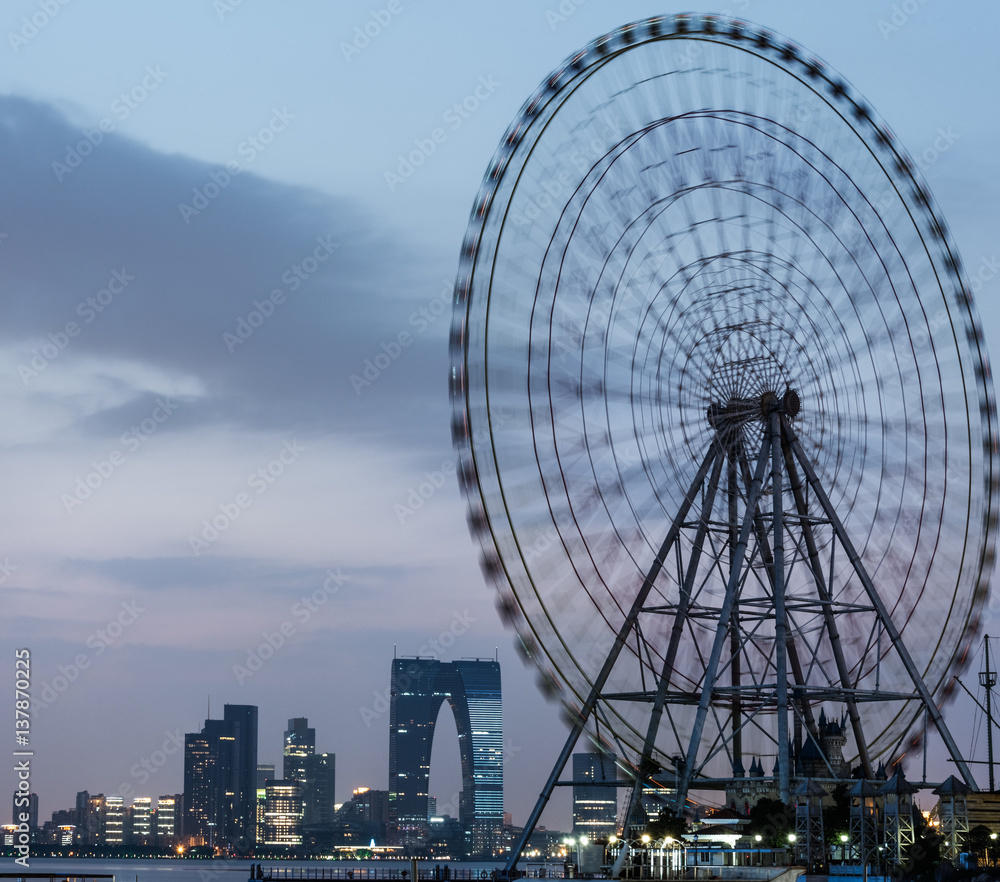 ferris wheel with cityscape in background in Suzhou,China.