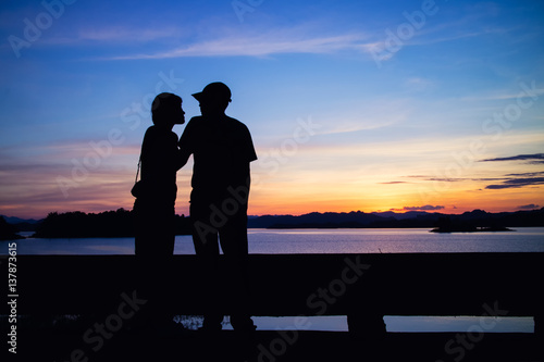 Silhouette of lovely couple on lake