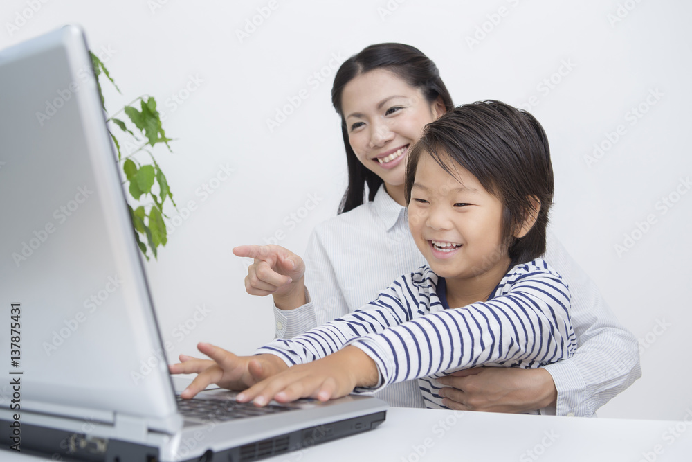 パソコンをする子供と女性