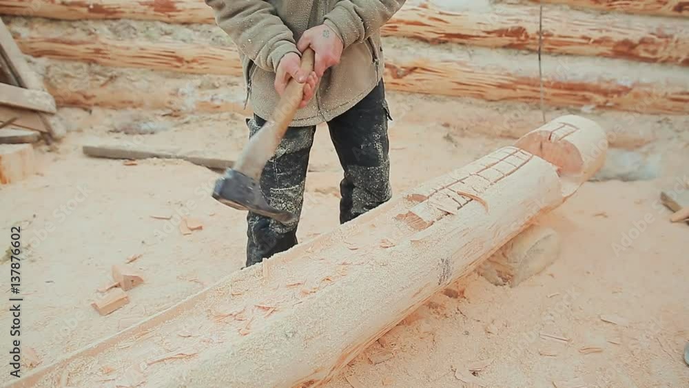 Carpenter carve a semicircle in the log. Canadian angle masonry. Canadian style. Wooden house made of logs. Carpenter carve a semicircle in the log. Canadian angle masonry. Canadian style. Wooden house made of logs.