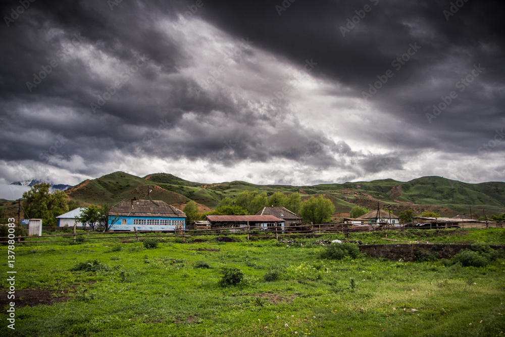 House near the mountains and beautiful cloudy sky, Kazakhstan
