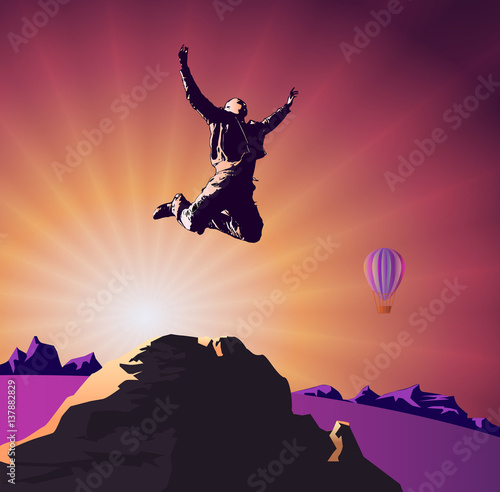 Success, victory, goal, man jumping on top of the mountain on the background of the rising sun and a hot air balloon.