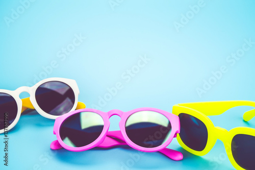 group of colorful sunglasses at light blue studio background.Summer Holiday concept.leave space for adding text