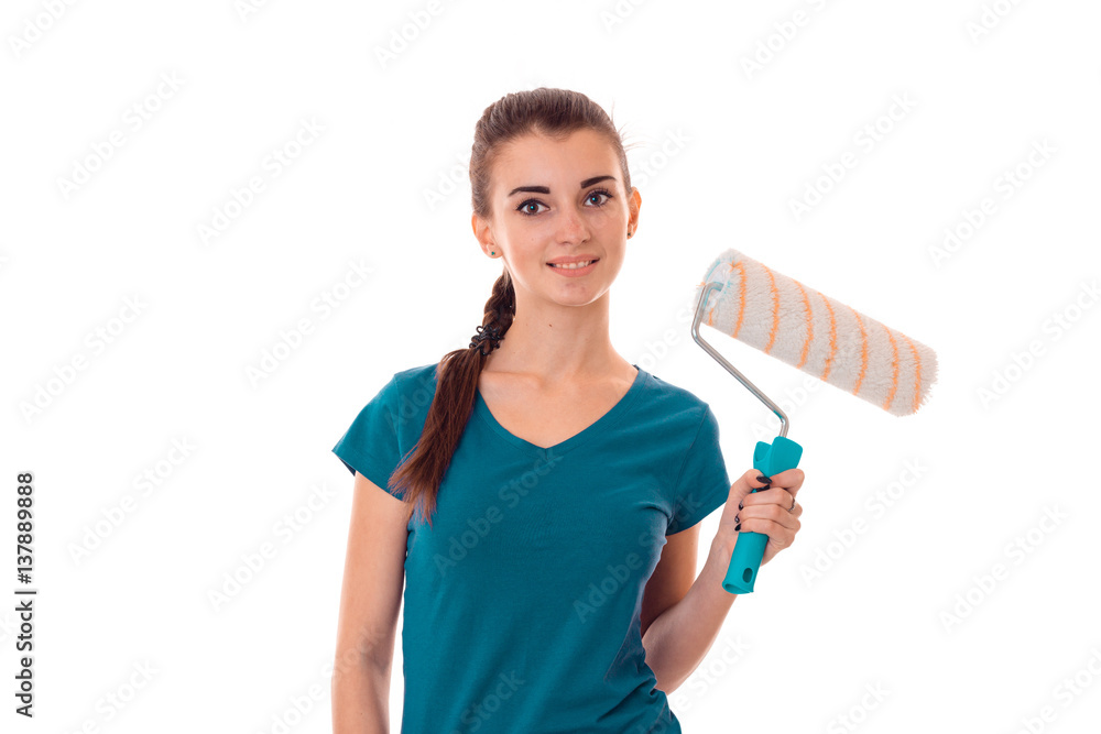 a young girl stands smiling and holding a roller for painting isolated on white background a young girl stands smiling and holding a roller for painting isolated on white background
