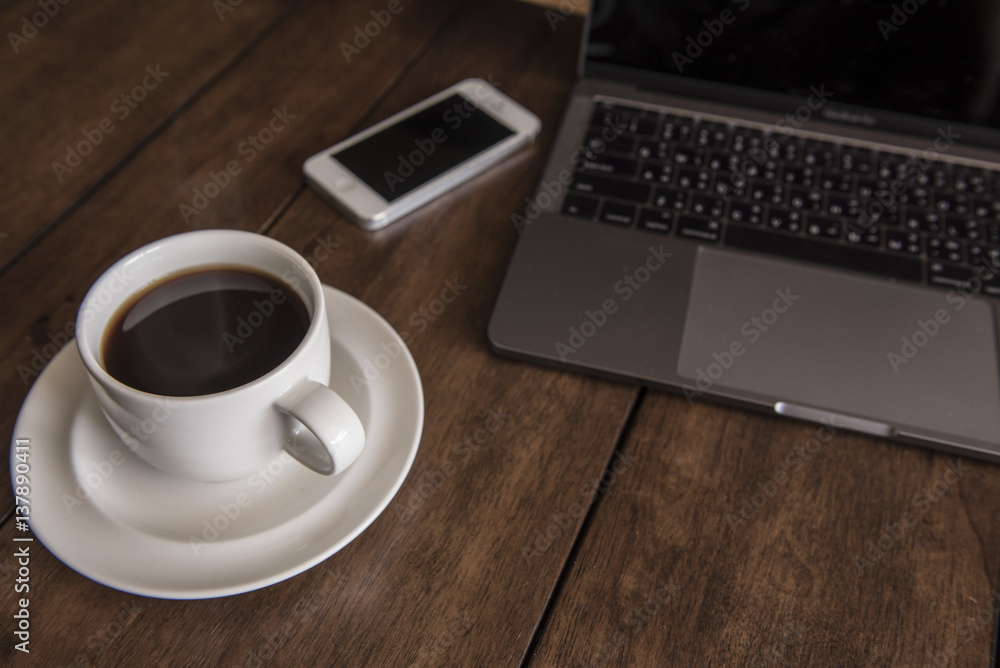 Working space , hot coffee , smartphone and laptop on wooden table Working space , hot coffee , smartphone and laptop on wooden table
