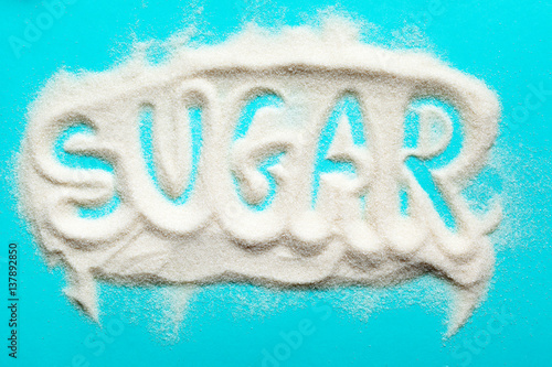 The word sugar written into a pile of white granulated sugar