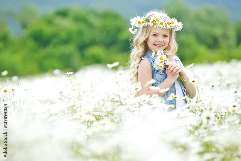 Fototapeta premium Little girl in a field of flowers
