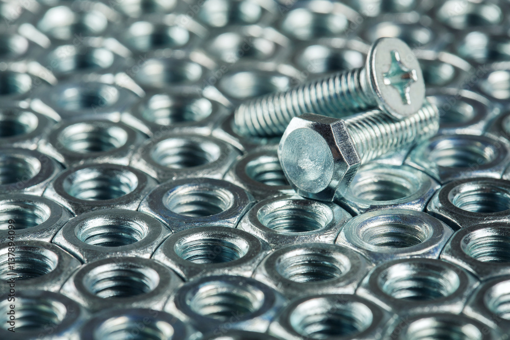 nuts, bolts, screws on a dark concrete background nuts, bolts, screws on a dark concrete background
