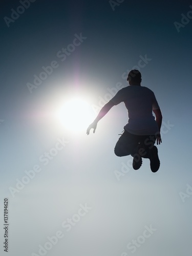 Man fly in air. Blue Toned effect. Man falling down with hands up.
