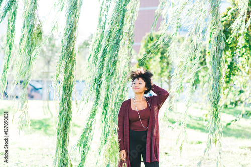 Young beautiful afro black woman looking at camera outdoor in the city malincholic - rhinking future, serious, pensive concept photo