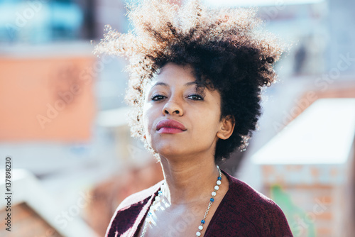 Portrait of young beautiful afro black woman looking at camera resolute - determination, resolved, woman power concept
