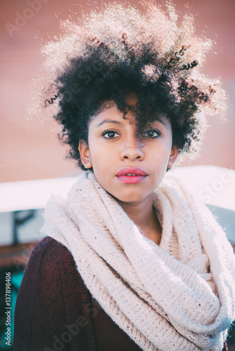 Portrait of young beautiful afro black woman looking at camera outdoor in the city malincholic - rhinking future, serious, pensive concept photo