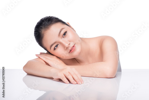 Facial treatment. Beautiful Young Asian Woman with Clean Fresh Skin touch her face