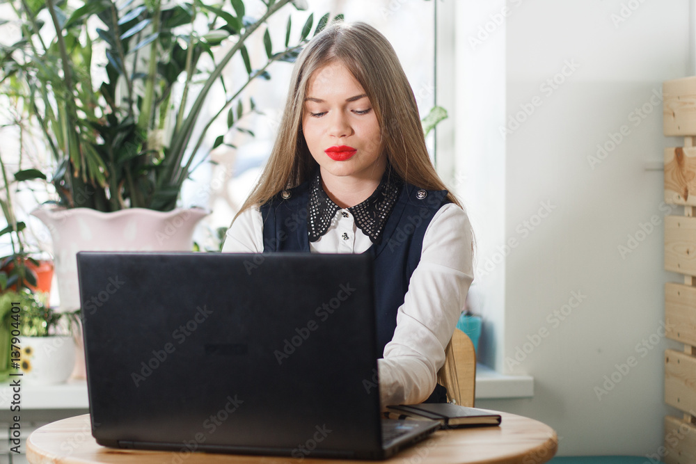 Portrait of a happy casual businesswoman in sweater sitting at her workplace in office Portrait of a happy casual businesswoman in sweater sitting at her workplace in office