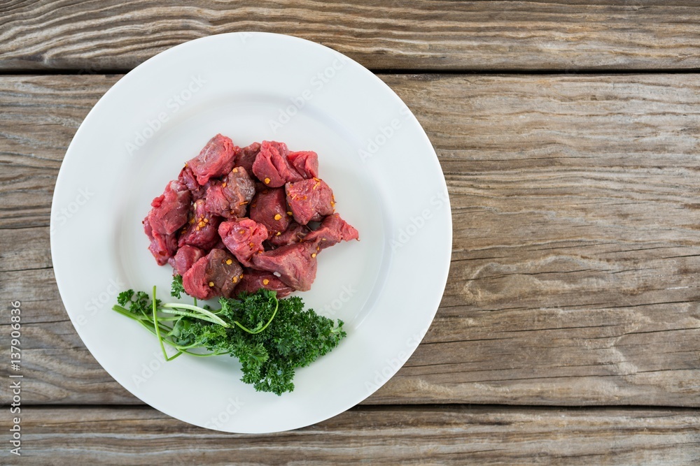 Diced beef and corainder leaves in white plate Diced beef and corainder leaves in white plate