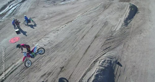 MotorCross rider on the track making a jump, aerial view from a drone