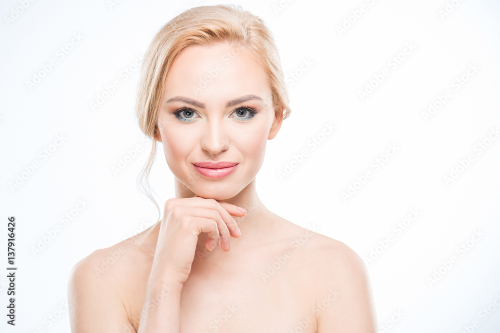 Gorgeous naked blonde woman with hand on chin smiling at camera, body care concept Gorgeous naked blonde woman with hand on chin smiling at camera, body care concept
