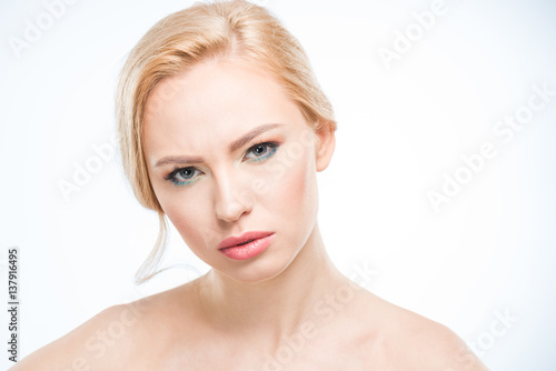 Beautiful young serious woman with stylish makeup looking at camera  skincare concept