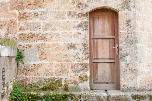 wall with wooden vintage door. © luengo_ua