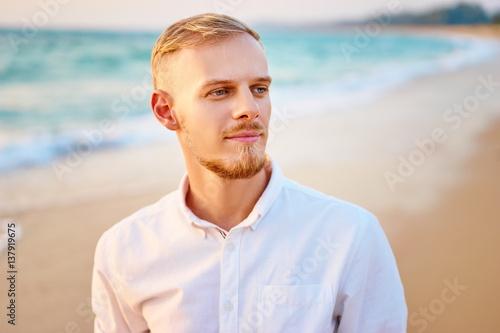 Close up portrait of young handsome man on the sea shore.
