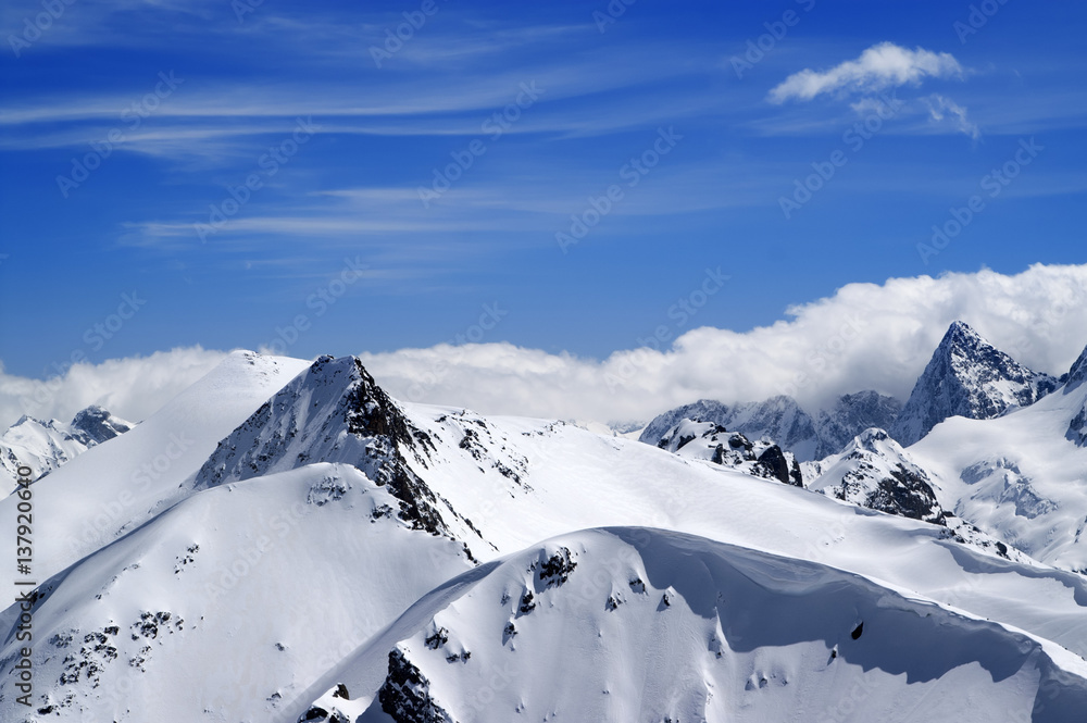 Winter mountains with snow cornice and blue sky with clouds in nice winter day