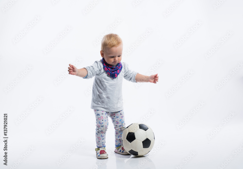 Cute little girl playing with soccer ball. Studio shot. Cute little girl playing with soccer ball. Studio shot.