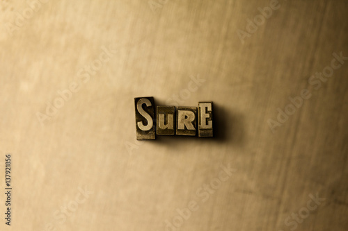 Photography SURE - close-up of grungy vintage typeset word on metal backdrop