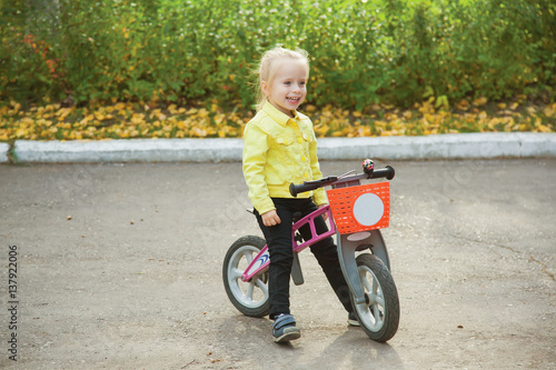 Fototapeta Naklejka Na Ścianę i Meble -  Cute little girl on pushbike. Expression. Emotions.