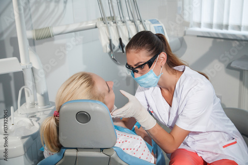 Female dentist examining a patient in the dental office for a woman