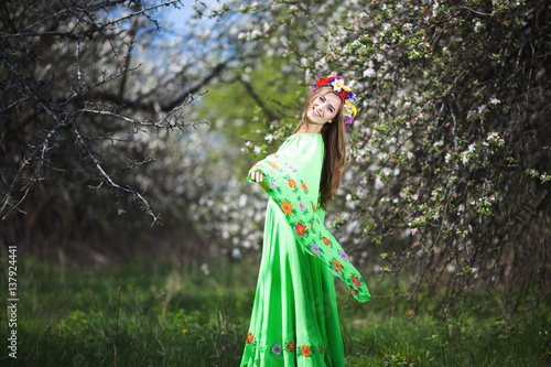 Portrait of beautiful natural smiling woman in nice green dress in the garden of apple