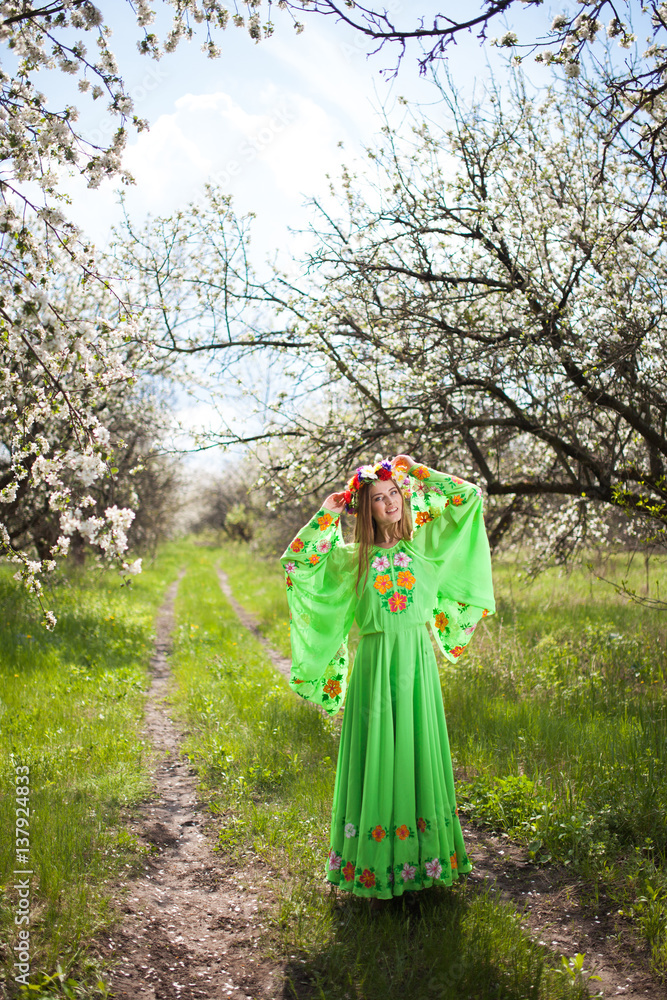 Portrait of beautiful natural smiling woman in nice green dress in the garden of apple