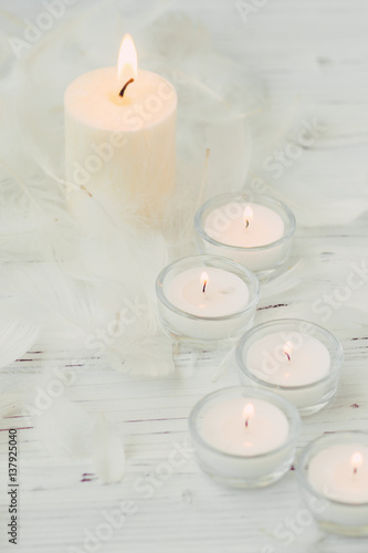 white palm candle with natural decoration for spa on white wooden table
