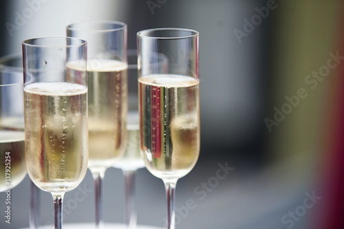 Dish with champagne and wine glasses. On outdoor wedding reception in summer.