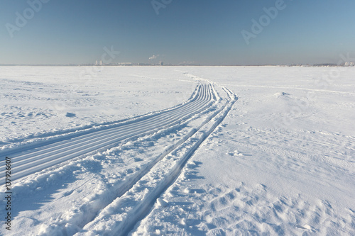 Trace of a snowmobile and sled on a snowy surface of frozen reservoir, Siberia,  Ob River © Nataliia Makarova