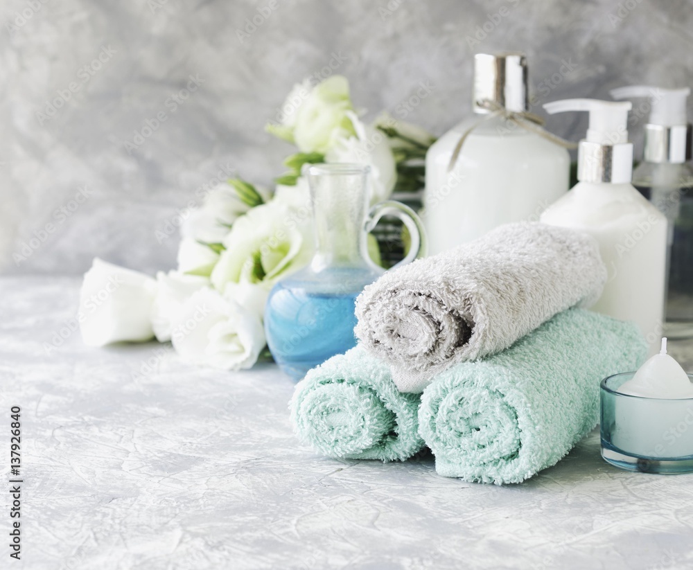 Spa set on a white marble table with a stack of towels, selective focus Spa set on a white marble table with a stack of towels, selective focus