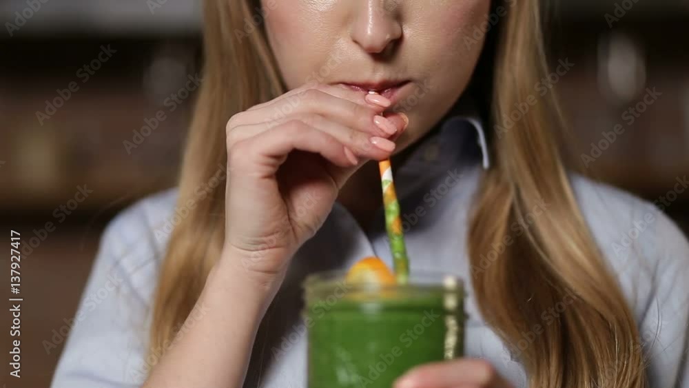 Woman drinking green detox vegetable smoothie Woman drinking green detox vegetable smoothie