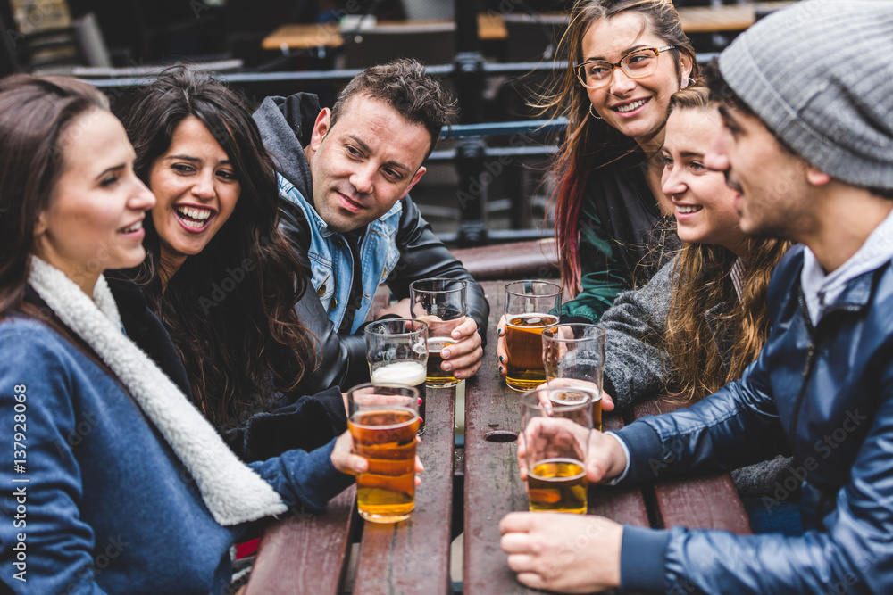 Group of friends enjoying a beer at pub in London