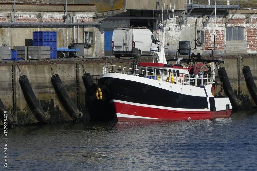 Red and Black fishing boat docked at the pier