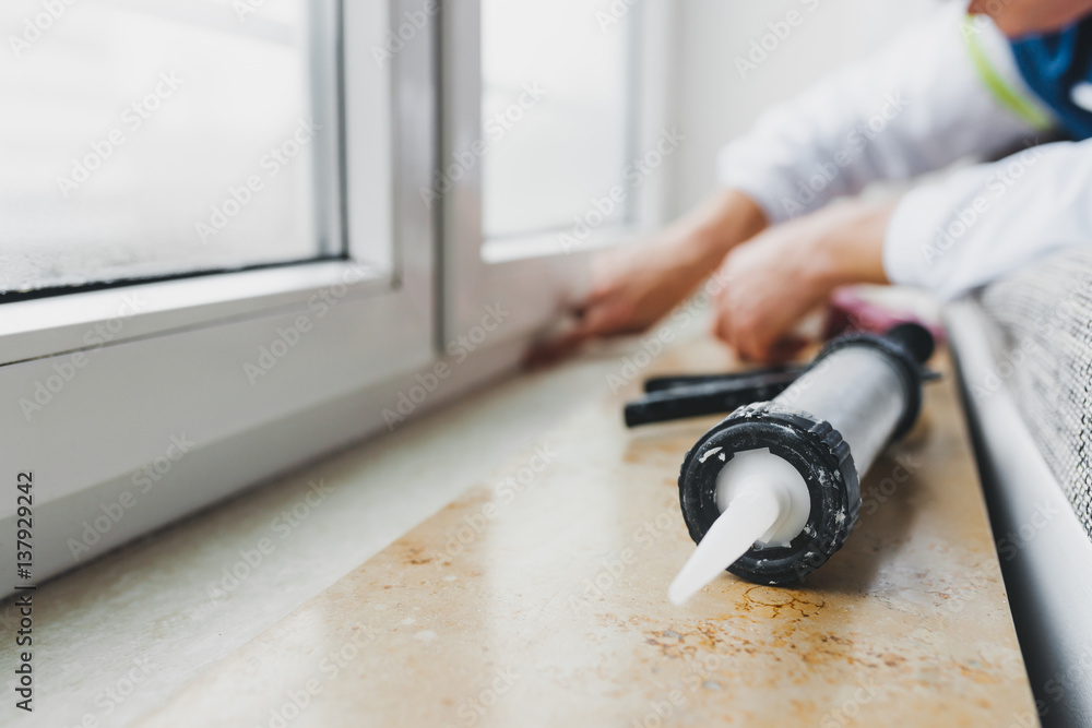 Ταπετσαρία Hands of worker using a silicone tube  for repairing of window