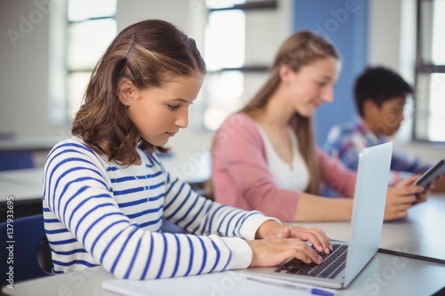 Students using digital tablet and laptop in classroom © WavebreakMediaMicro