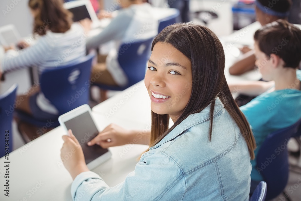 Student holding digital tablet in classroom Student holding digital tablet in classroom
